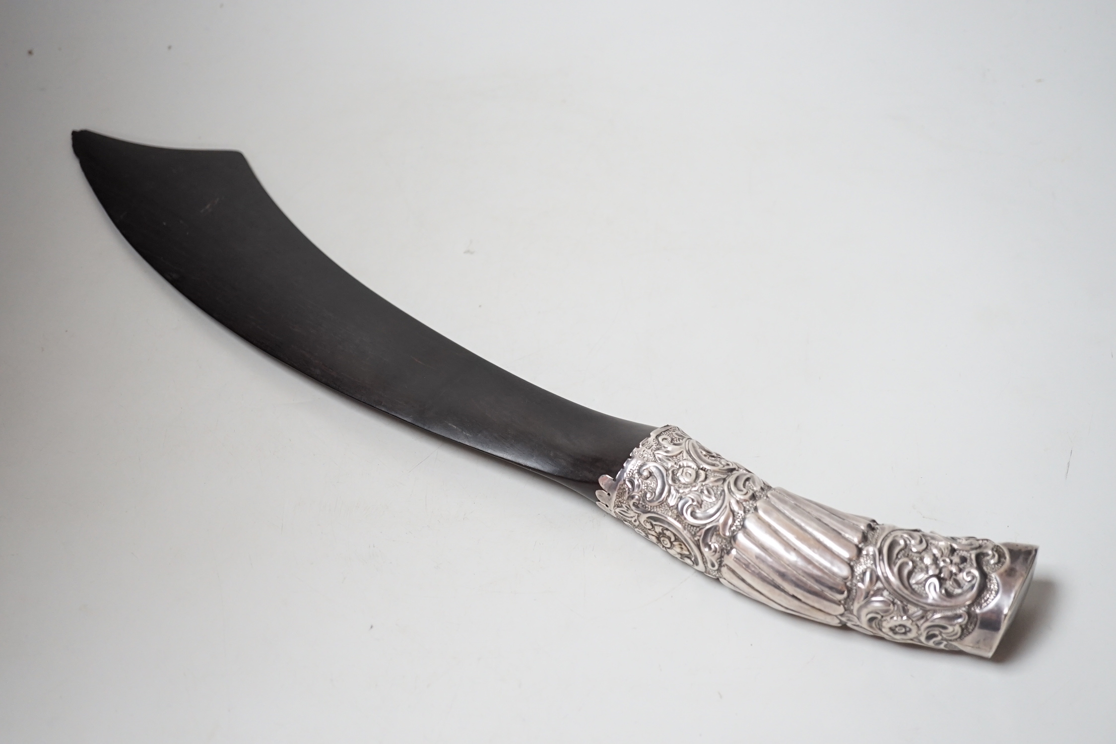 A Victorian repoouse silver handled ebony 'scimitar' page turner, Rosenthal, Jacob & Co, London, 1889, 48.9cm.